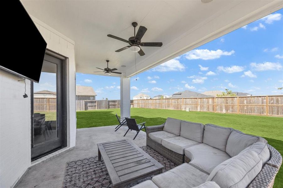 Spacious covered patio with ceiling fans, and plenty of room for seating.