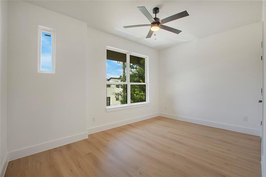 Empty room with light hardwood / wood-style flooring and ceiling fan