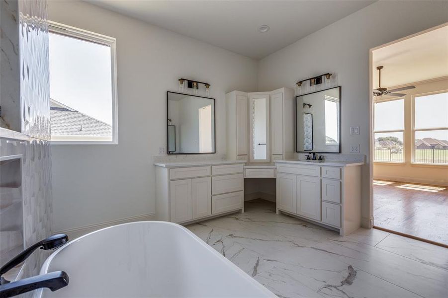 Bathroom featuring ceiling fan, wood-type flooring, vanity, and a bath