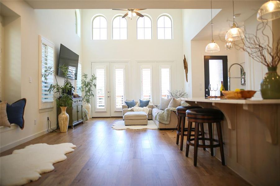 Foyer with ceiling fan, french doors, a towering ceiling, and wood-type flooring