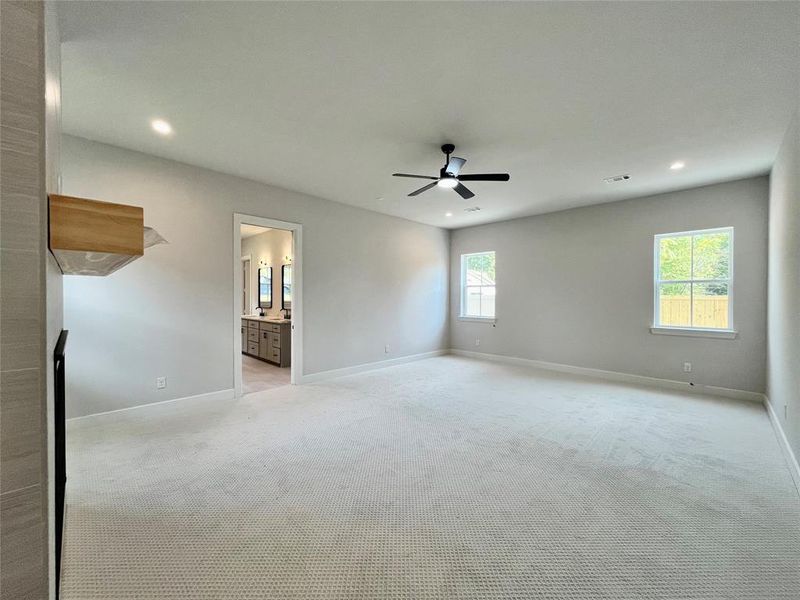 Spare room with plenty of natural light, ceiling fan, and light carpet