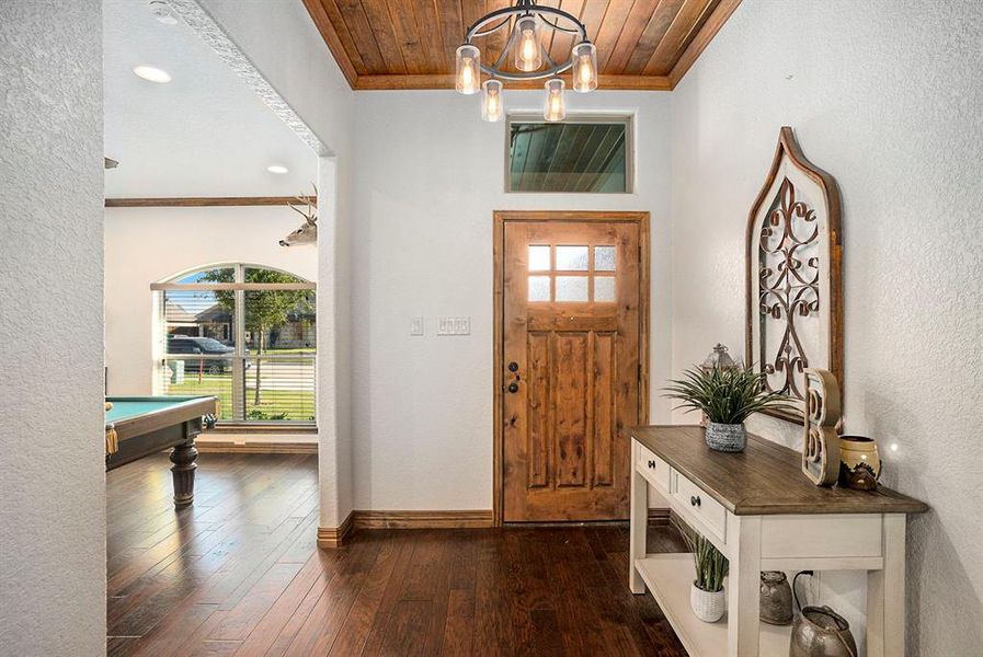 Entrance foyer featuring crown molding, wooden ceiling, and dark hardwood / wood-style flooring