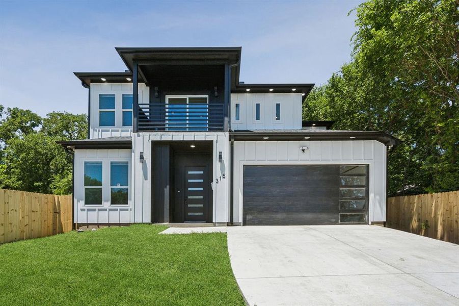 Modern home with a balcony, a garage, and a front yard