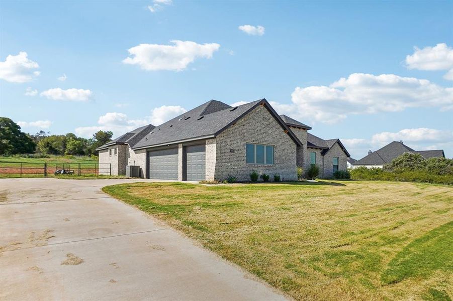 View of side of home featuring a yard and a garage