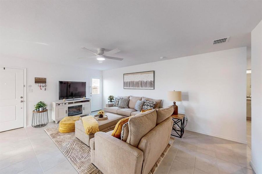 Tiled living room featuring a fireplace and ceiling fan