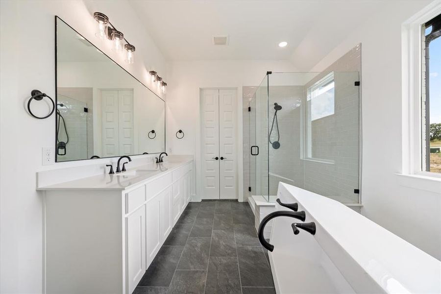 Bathroom with double vanity, separate shower and tub, and tile patterned floors