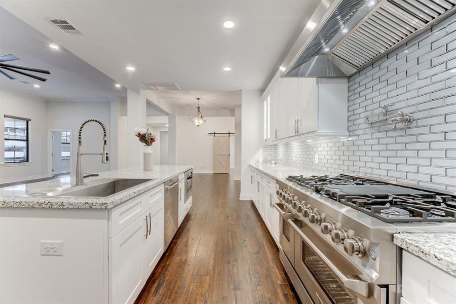 This view of the kitchen highlights the function afforded by the long countertop spaces and the large center island.