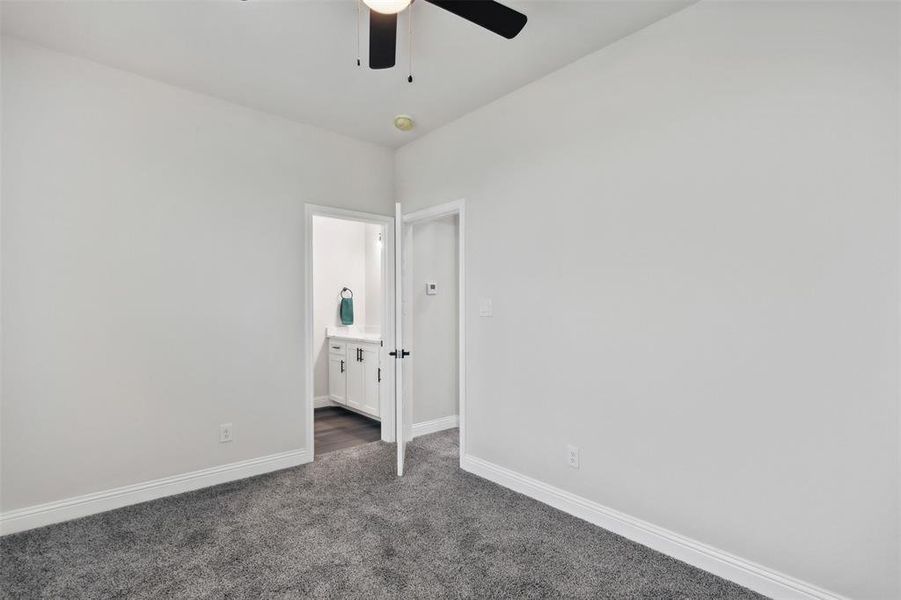 Empty room featuring ceiling fan and carpet floors