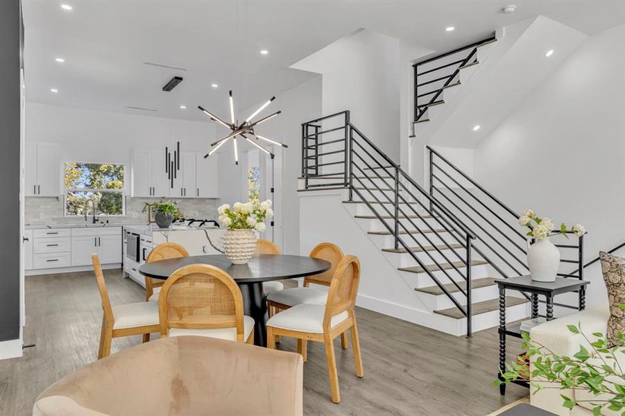 Dining room with light hardwood / wood-style floors, a notable chandelier, and sink