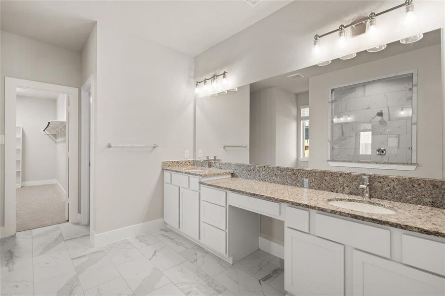 This primary bathroom is definitely move-in ready! Featuring white stained cabinets with light countertops, spacious walk-in closet with shelving, high ceilings, custom paint, sleek and dark modern finishes.