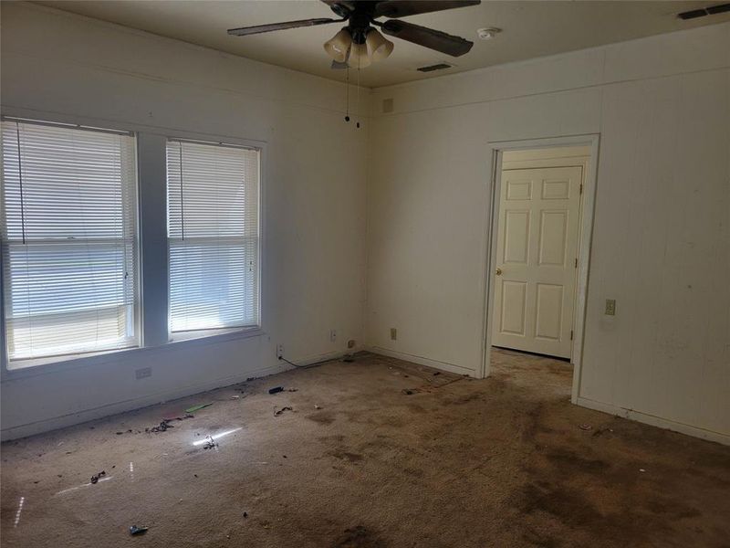 Carpeted empty room featuring ceiling fan