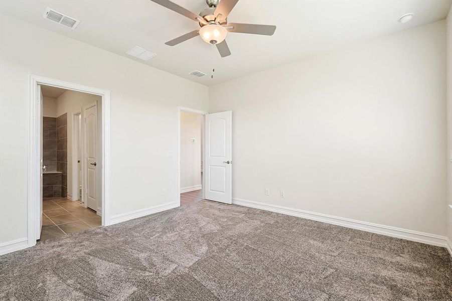 Unfurnished bedroom with light colored carpet and ceiling fan