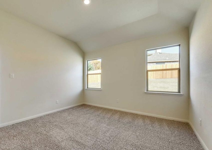 The master suite has back yard views, white walls and brown carpet.