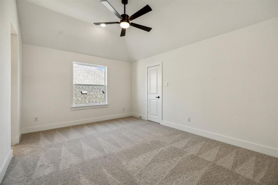 Spare room featuring high vaulted ceiling, ceiling fan, and light carpet