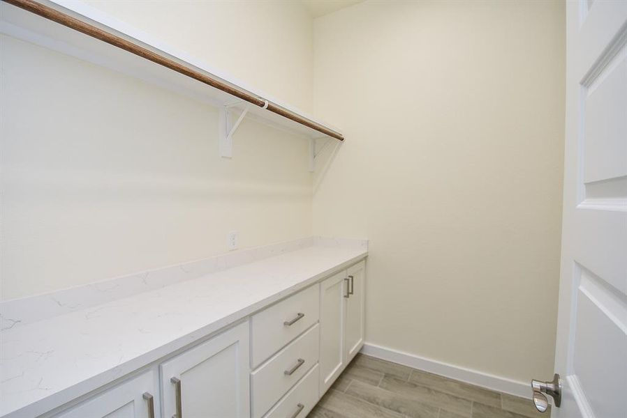Fantastic laundry room featuring extra cabinet space and drawers, and quartz countertops!