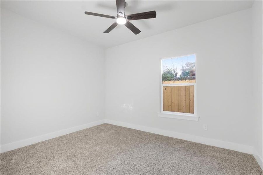 Spare room with ceiling fan and carpet