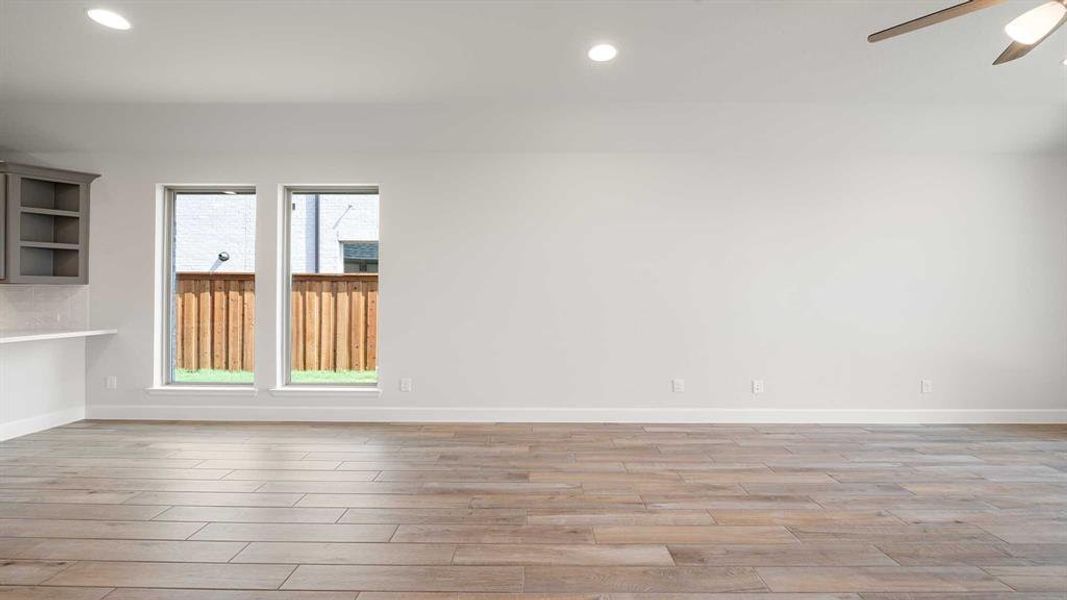 Spare room featuring ceiling fan, light hardwood / wood-style floors, and plenty of natural light