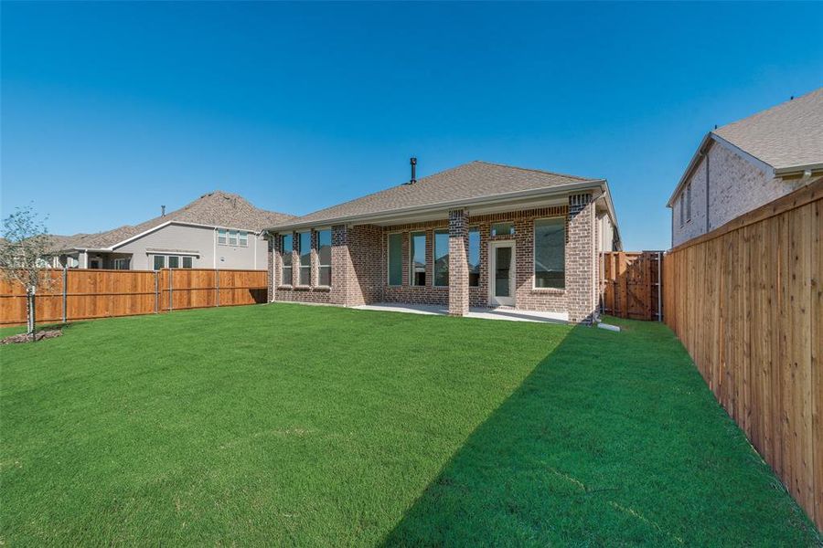 Rear view of property with a lawn and a patio area