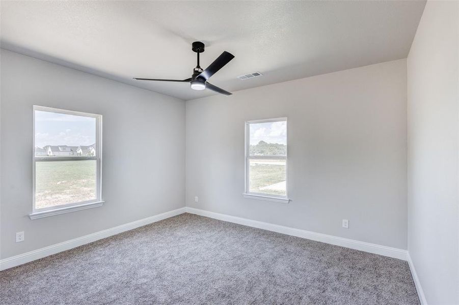 Carpeted empty room with ceiling fan