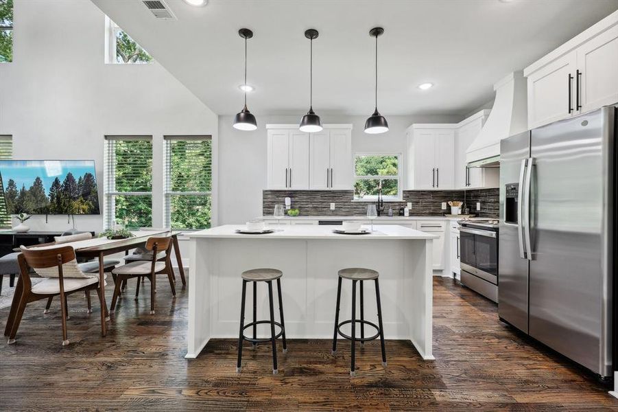 Kitchen featuring tasteful backsplash, stainless steel appliances, pendant lighting, dark hardwood / wood-style floors, and custom exhaust hood