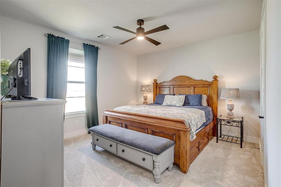 Carpeted bedroom featuring ceiling fan