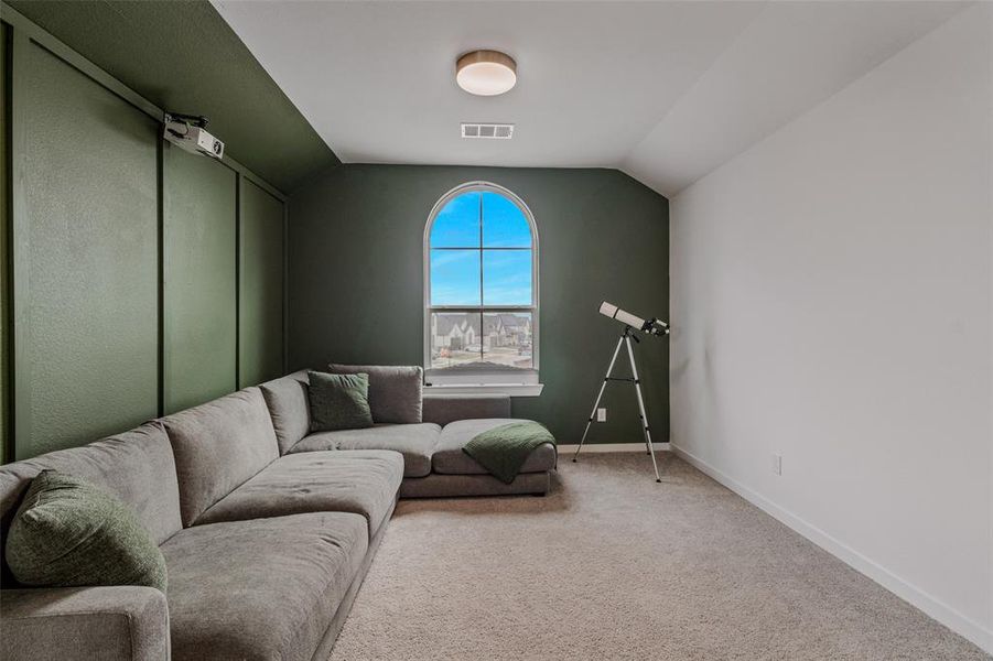 Carpeted living room with vaulted ceiling