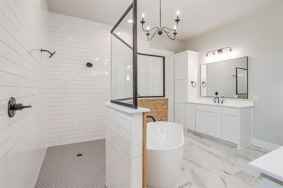 Bathroom featuring tile floors, vanity, plus walk in shower, and a chandelier