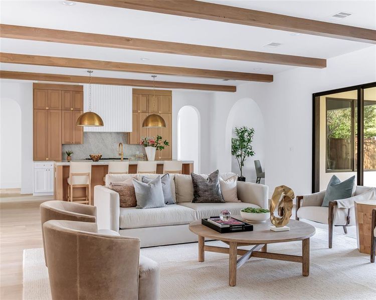 Living room with beamed ceiling and light hardwood / wood-style flooring