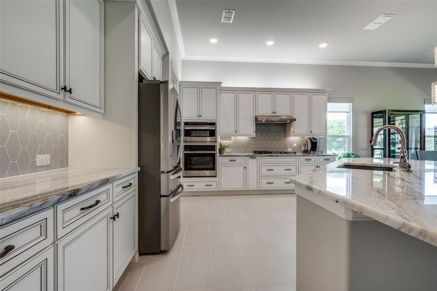 Kitchen featuring crown molding, tasteful backsplash, Dolomite counters