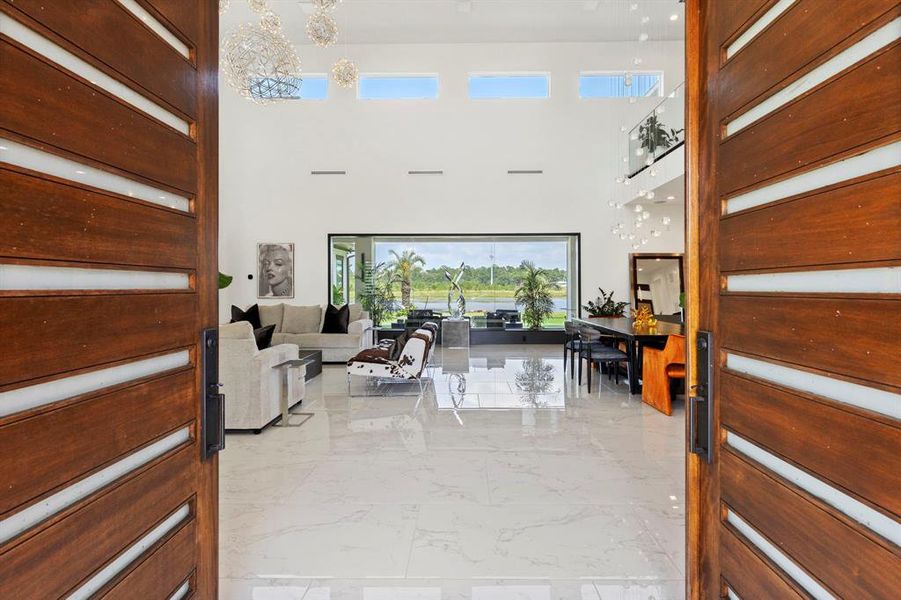 Gorgeous contemporary double doors with industrial frame open to soaring 21' high ceilings and captivating water view.