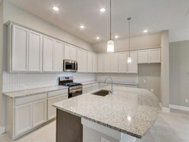 Modern kitchen showcasing stylish cabinets, a sleek granite countertop, and a chic backsplash.