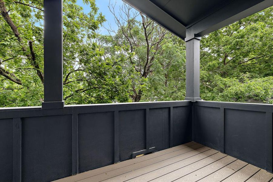 Right side of the spacious covered balcony surrounded by trees.