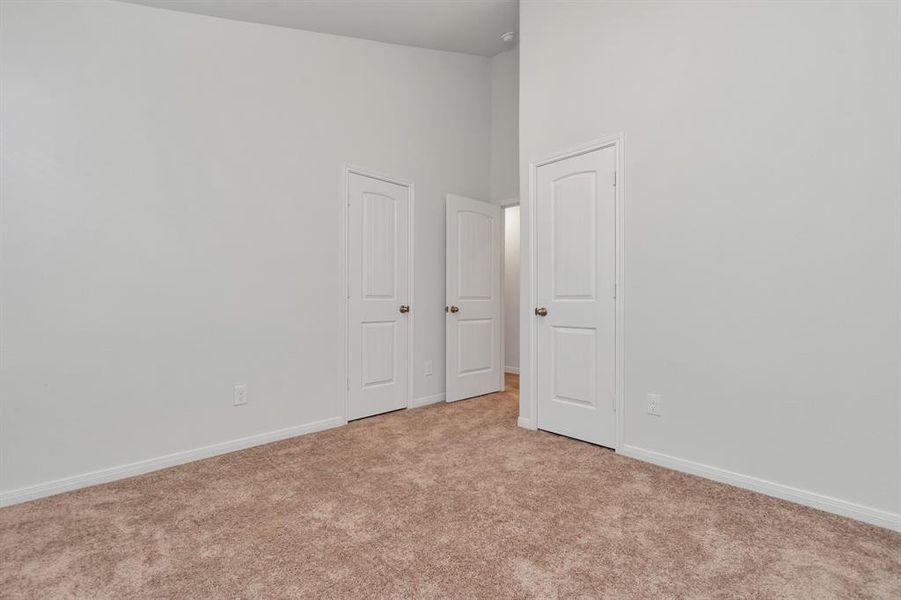 This bedroom boasts double-door closet access, providing plenty of storage. A perfect secondary bedroom or home office with easy access to other areas of the house. **This image is from another Saratoga Home - Clover floorplan.**