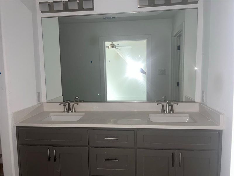 Bathroom featuring ceiling fan and dual bowl vanity