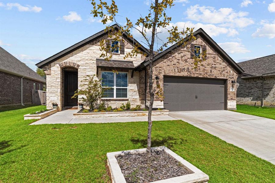 View of front facade with a garage and a front lawn