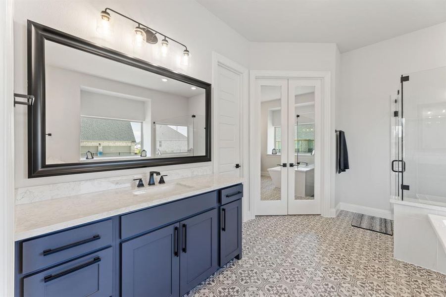 Bathroom featuring plus walk in shower, vanity, and french doors