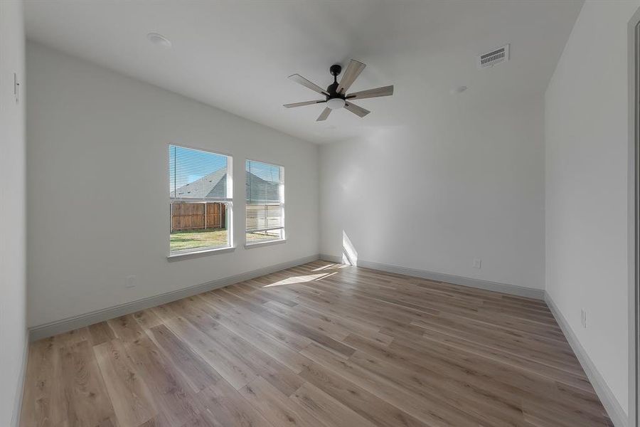 Empty room with light hardwood / wood-style floors and ceiling fan