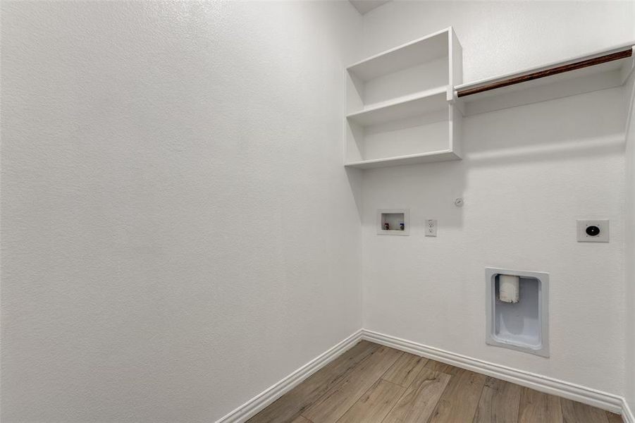 Laundry area with hookup for an electric dryer, light hardwood / wood-style floors, hookup for a washing machine, and hookup for a gas dryer