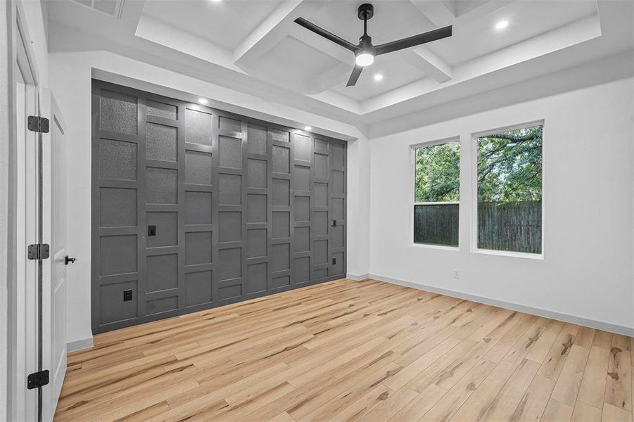 Spare room with ceiling fan, coffered ceiling, light wood-type flooring, and beam ceiling