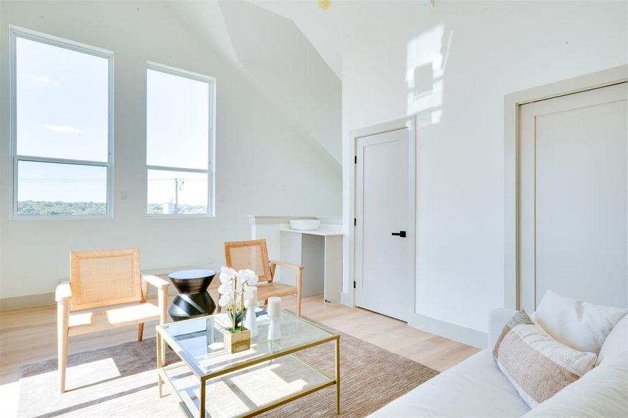 Sitting room featuring light wood-type flooring and vaulted ceiling