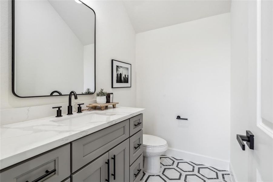 A generously sized powder room retreat features a clean, contemporary aesthetic. With sleek design and thoughtful details, it offers a luxurious experience for guests, blending style and comfort.