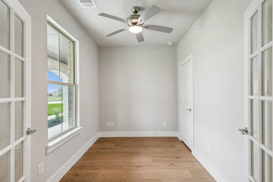 Unfurnished room featuring ceiling fan, light hardwood / wood-style flooring, and french doors