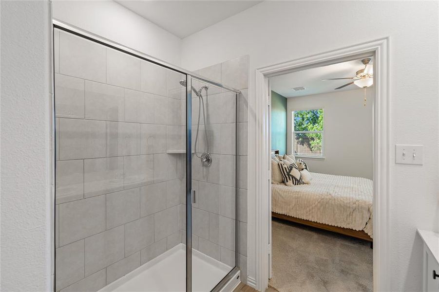 Bathroom with ceiling fan and a shower with door