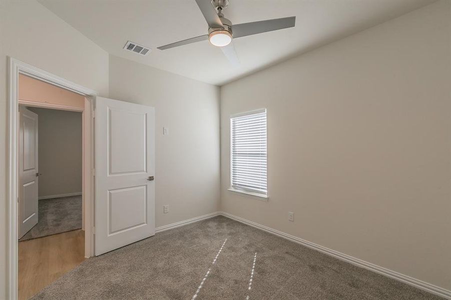 Spare room with ceiling fan and carpet