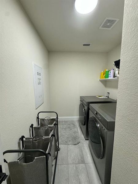 Laundry area featuring washer hookup, washer and clothes dryer, and light tile flooring