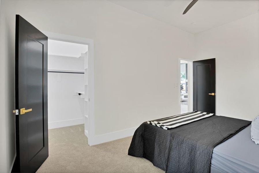 Carpeted bedroom with ceiling fan and a closet