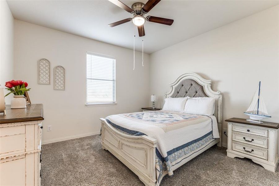 Bedroom with dark colored carpet and ceiling fan