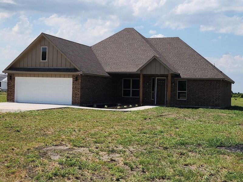 View of front of house featuring a garage and a front yard