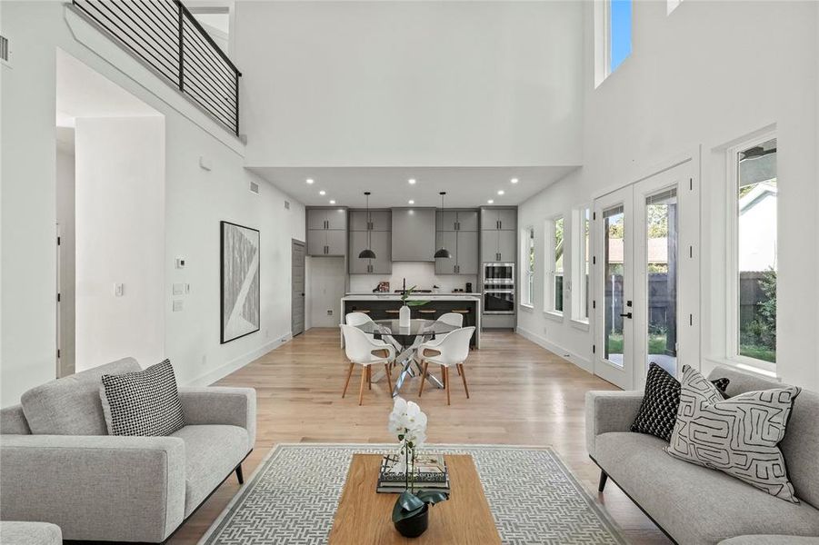 Living room featuring a high ceiling and light hardwood / wood-style floors