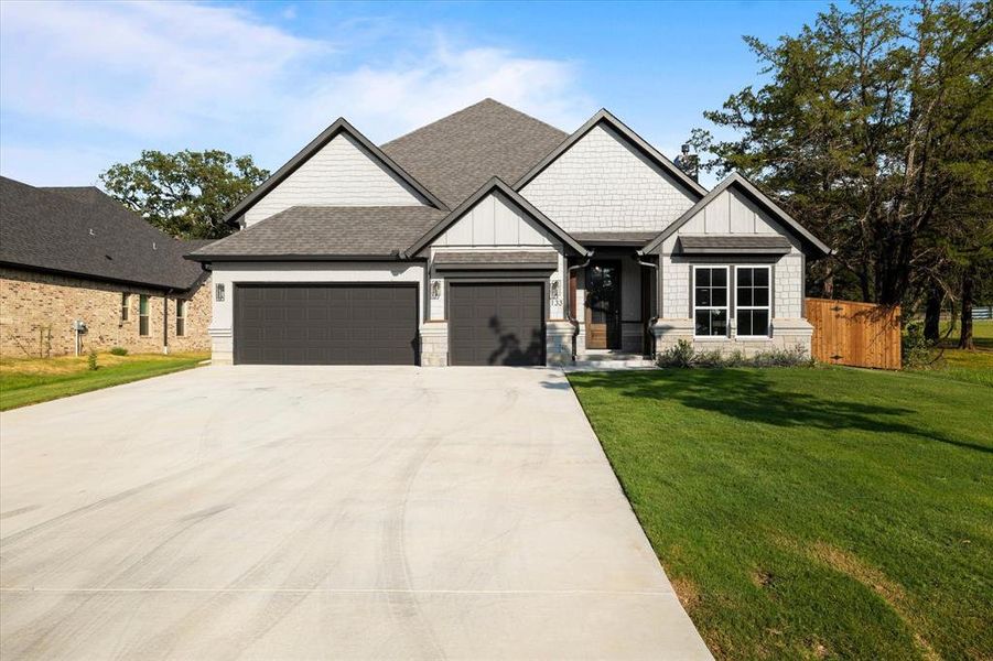 Craftsman house featuring a garage and a front lawn